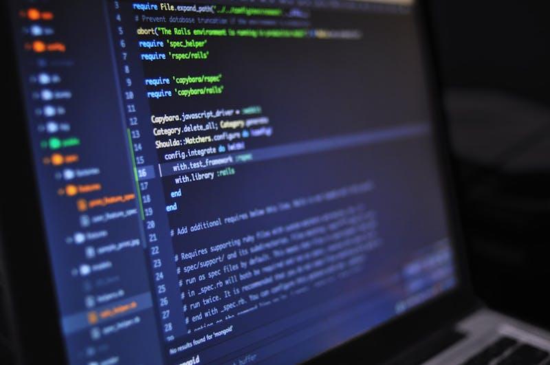 Engenheiro revisando código em vários monitores